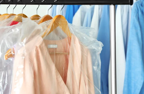Hangers with clean clothes in laundry — Stock Photo, Image