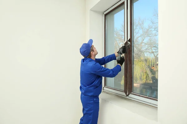 Bouwvakker herstellen venster in huis — Stockfoto
