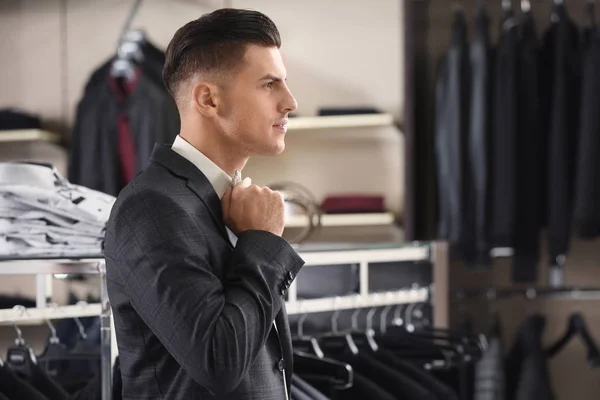 Joven guapo usando traje en la tienda —  Fotos de Stock