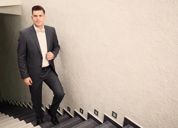 Junger Mann im eleganten Anzug auf der Treppe — Stockfoto