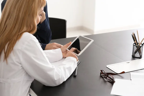 Doctora consultando a paciente joven en clínica —  Fotos de Stock