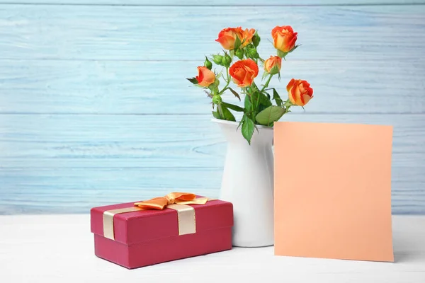 Rosen, leere Karte und Geschenkbox auf dem Tisch — Stockfoto