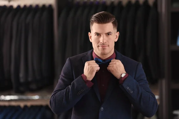 Hombre joven en traje elegante en la tienda de ropa de hombre —  Fotos de Stock