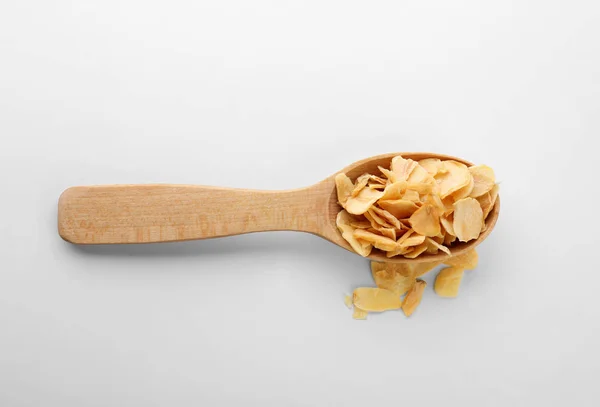 Copos de ajo secos en cuchara sobre fondo blanco — Foto de Stock