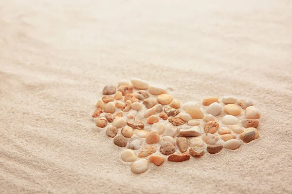 Coração feito de pedras na areia — Fotografia de Stock