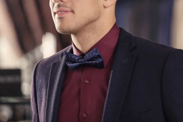 Young man in elegant suit on blurred background — Stock Photo, Image