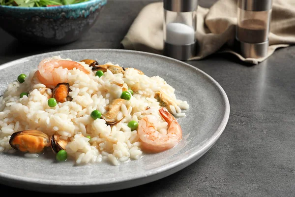 Plaat met heerlijke zeevruchten risotto op tafel — Stockfoto