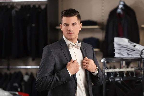 Handsome young man wearing suit in shop