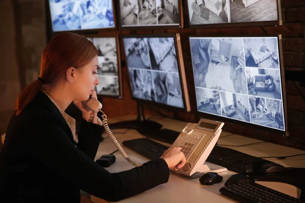 Mujer guardia de seguridad hablando por teléfono en la sala de vigilancia — Foto de Stock