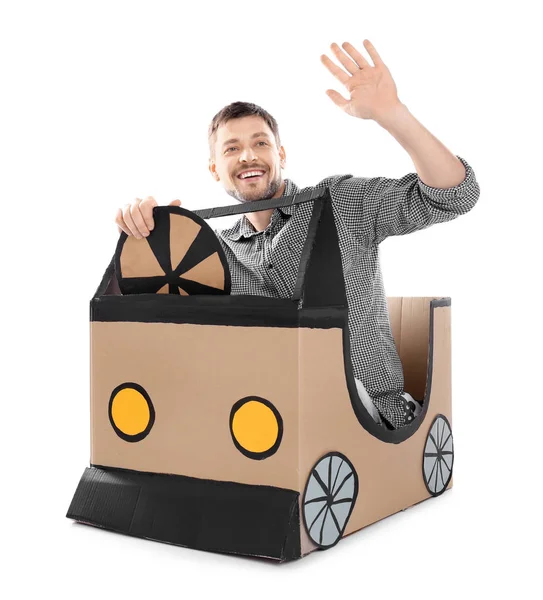 Young man dreaming of buying own auto while playing with cardboard car on white background — Stock Photo, Image
