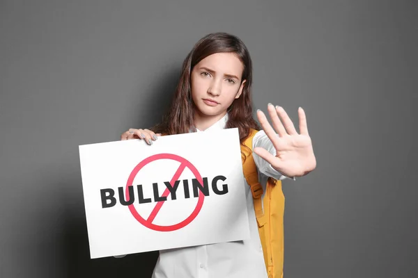 Genç kız işareti çapraz kelime ile "Bullying" gri arka plan üzerinde tutarak. — Stok fotoğraf