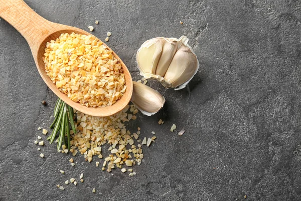 Vařečka s granulovaný sušený česnek na šedém pozadí — Stock fotografie