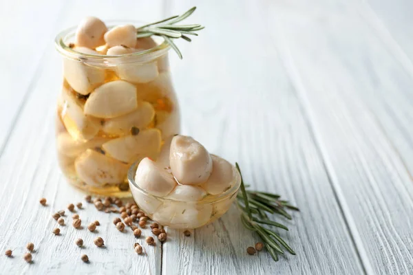 Preserved garlic in glassware on table — Stock Photo, Image