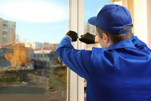 Bouwvakker herstellen venster in huis — Stockfoto