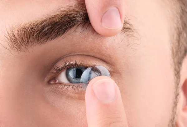 Joven poniendo lentes de contacto en su ojo, primer plano — Foto de Stock