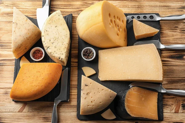 Diferentes tipos de deliciosos queijos na mesa de madeira — Fotografia de Stock