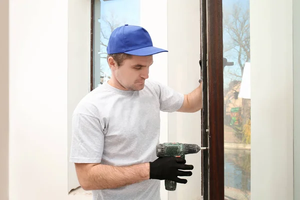 Trabalhador da construção reparando janela em casa — Fotografia de Stock