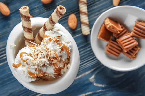 木桌上的冰淇淋和焦糖酱碗 — 图库照片