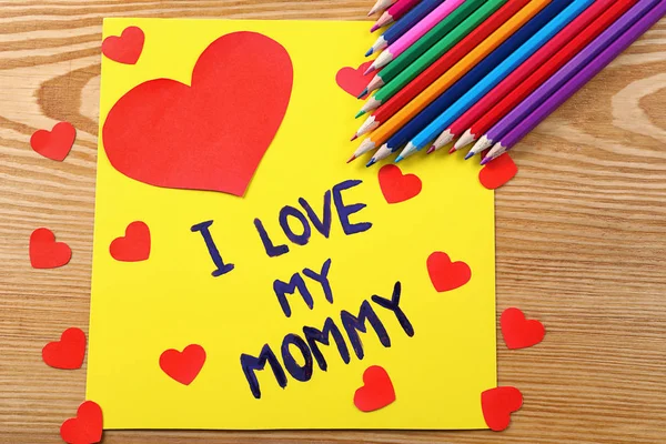 Linda tarjeta hecha a mano con texto Me encanta mi mamá en la mesa de madera. Celebración del día de la madre — Foto de Stock