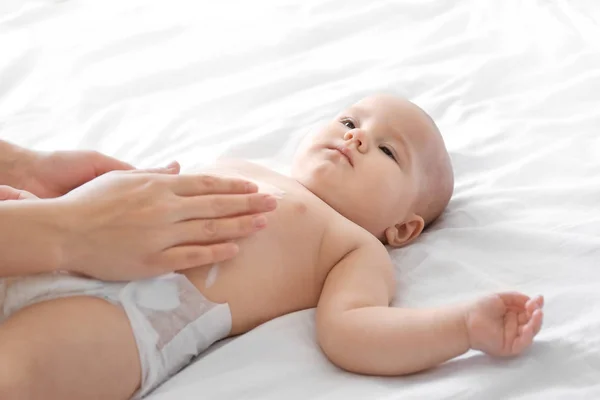 Mujer aplicando crema corporal en su bebé en el interior —  Fotos de Stock