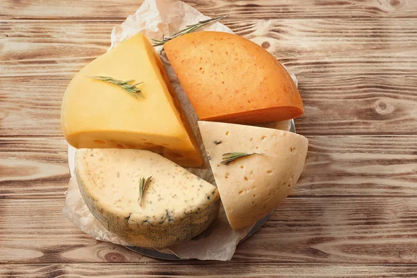 Diferentes tipos de deliciosos queijos na mesa de madeira — Fotografia de Stock