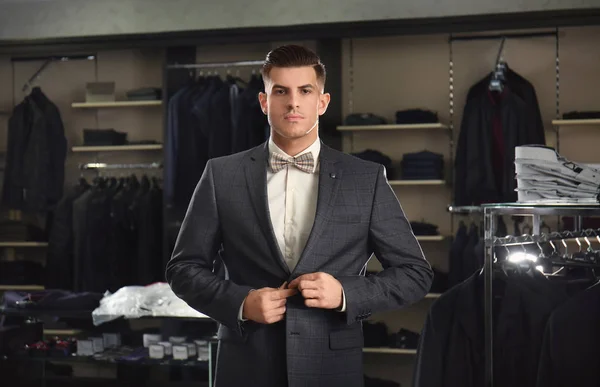 Handsome young man wearing suit in shop — Stock Photo, Image