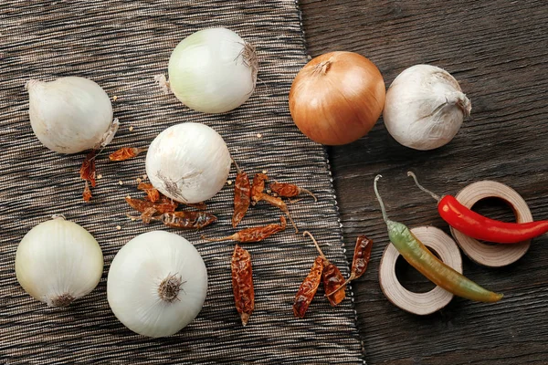 Komposition mit frischen Zwiebeln und Chilischoten auf dem Tisch — Stockfoto