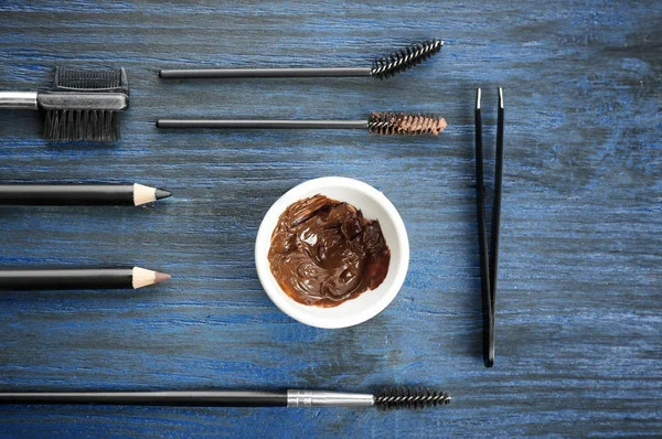 Tools for eyebrow dyeing and correction on wooden background