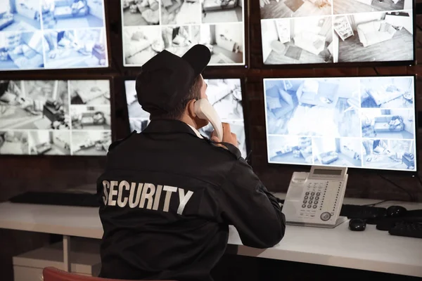Hombre guardia de seguridad hablando por teléfono en la sala de vigilancia — Foto de Stock