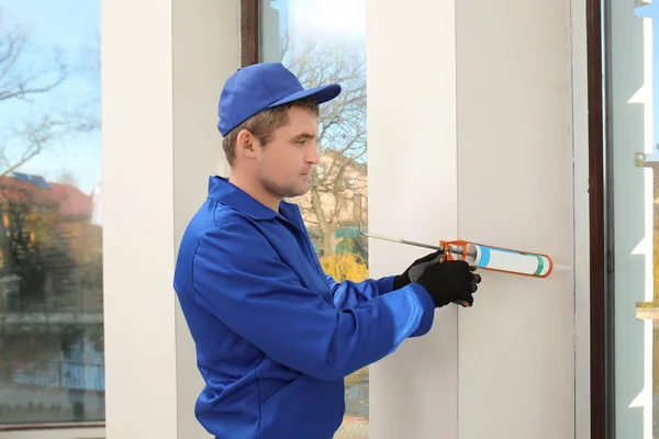 Bouwvakker herstellen venster in huis — Stockfoto