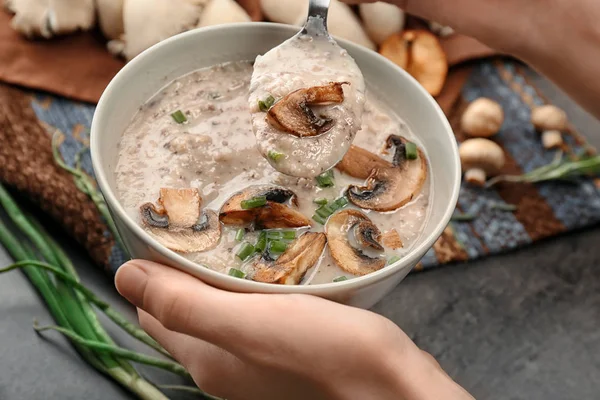 Junge Frau isst köstliche Pilzsuppe am Tisch — Stockfoto