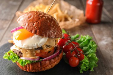 Kayrak plaka üzerinde kızarmış yumurta ile lezzetli burger