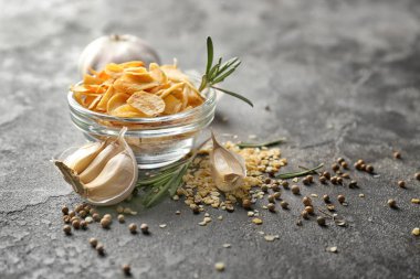 Cam kase kuru sarımsak gevreği gri arka plan üzerinde ile