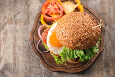 Ahşap masa kızarmış yumurta ile lezzetli burger
