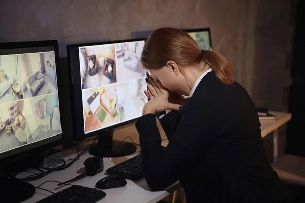 Tired female security guard in surveillance room