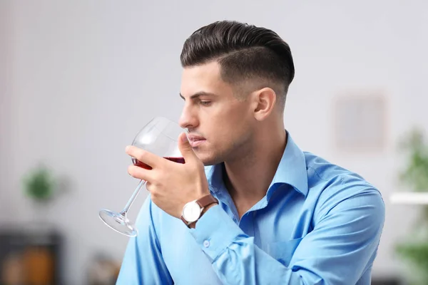Красивый мужчина с бокалом вина расслабляющий дома — стоковое фото