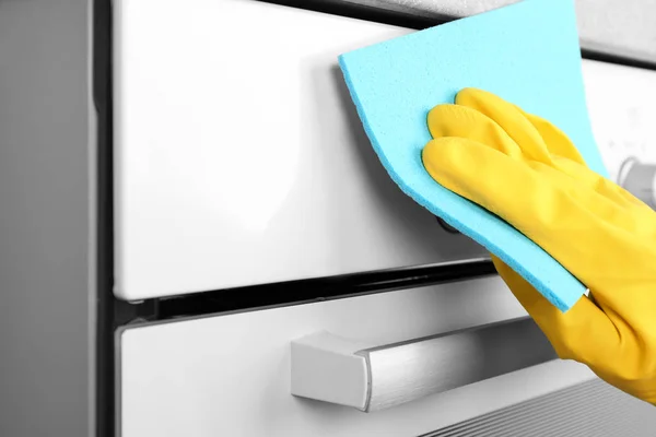 Huisvrouw reiniging oven in keuken — Stockfoto