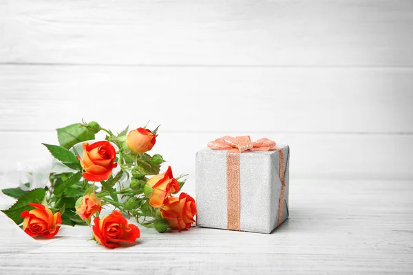 Róże i pudełko na stole — Zdjęcie stockowe