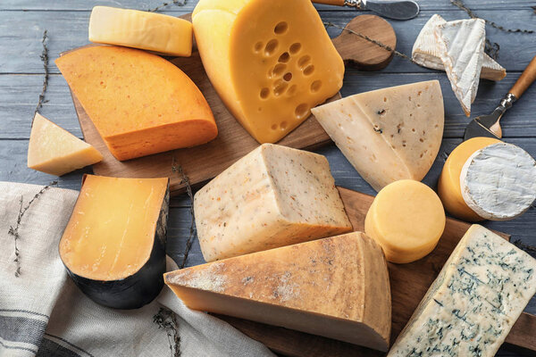 Different types of delicious cheese on wooden table