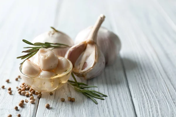 Preserved garlic in glass bowl on table — Stock Photo, Image