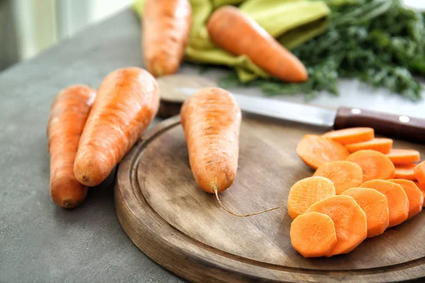 Tavola di legno con carota affettata sul tavolo, primo piano — Foto Stock