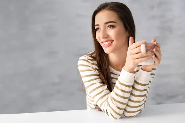 Mulher sorridente bonita com xícara de café em casa — Fotografia de Stock