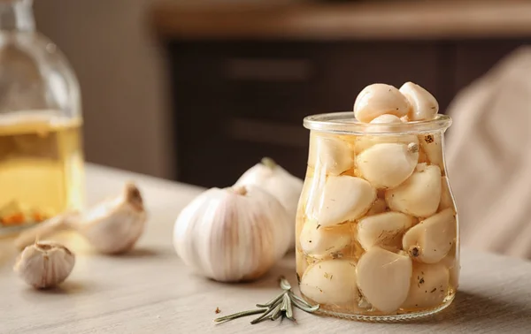 Aglio conservato in vaso di vetro sul tavolo — Foto Stock