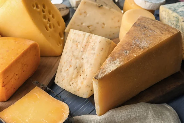 Different types of delicious cheese on wooden table — Stock Photo, Image