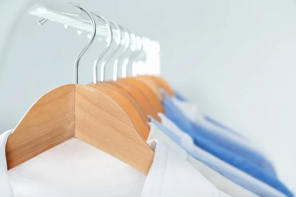 Cabides com camisas limpas na lavanderia, close-up — Fotografia de Stock