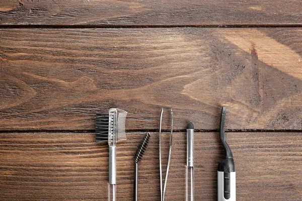 Hulpmiddelen voor het verven van wenkbrauwen en correctie op houten achtergrond — Stockfoto