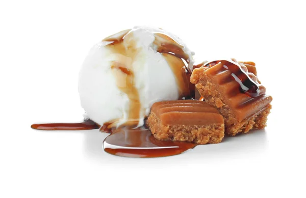 Bola de sorvete com molho de caramelo e doces no fundo branco — Fotografia de Stock