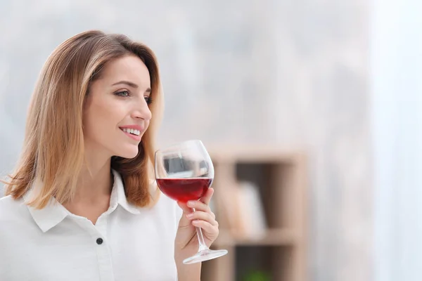 Schöne junge Frau mit einem Glas Wein entspannt zu Hause — Stockfoto