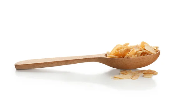 Dried garlic flakes in spoon on white background — Stock Photo, Image