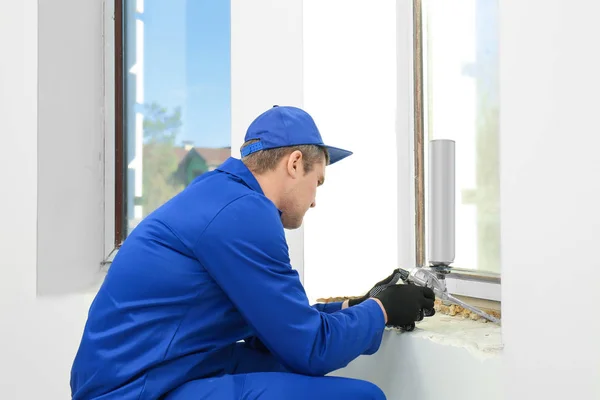 Construction worker repairing window in house — Stock Photo, Image